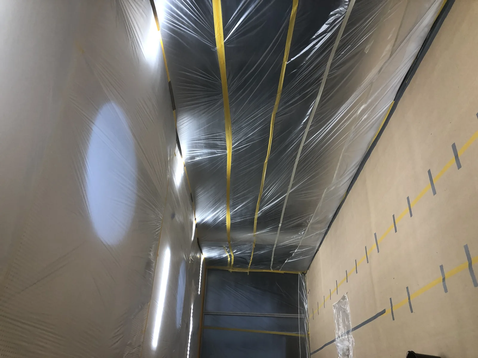 Ein Flur im Forschungsinstitut DESY, komplett in Schutzfolie eingehaust, silbrig glänzende Bahnen und gelbes Klebeband am Boden
