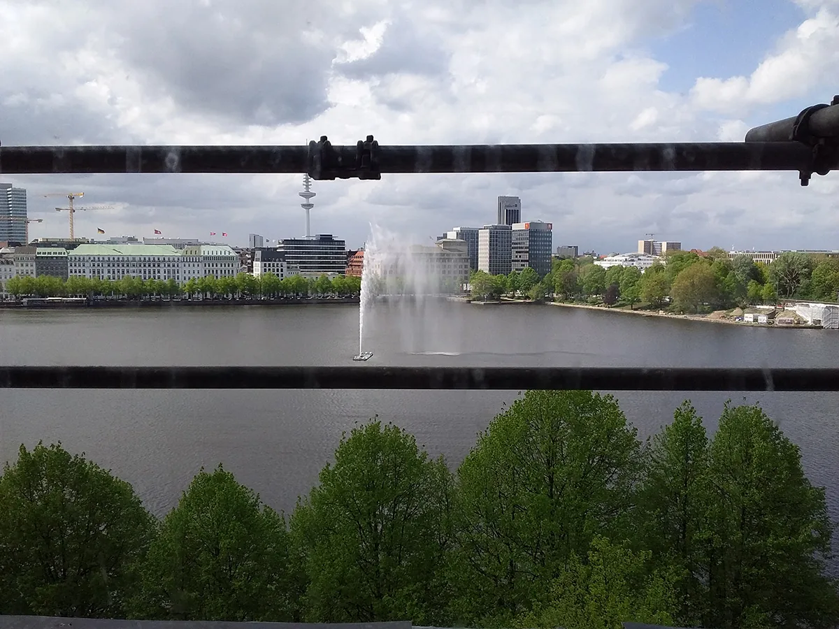 Blick über die Hamburger Außenalster mit Fontäne, Baumreihe im Vordergrund