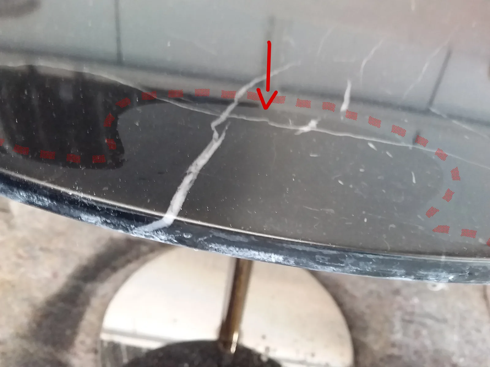 Schwarze Marmorplatte mit einem durchgehenden Riss, rot markiert